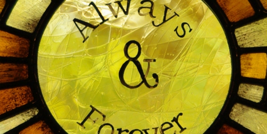 close up of yellow sun in stained glass with text, always & forever