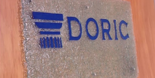 fused glass sign with doric logo in blue glass
