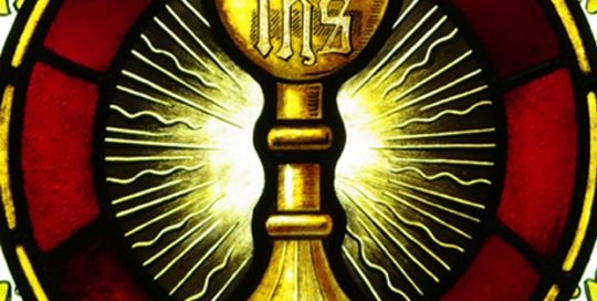 circular part of stained glass window with serpent coming out of chalise