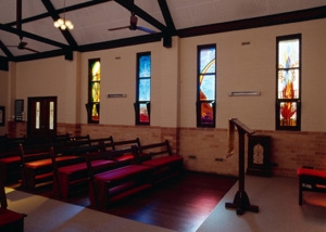 inside of chapel with four stained glass windows