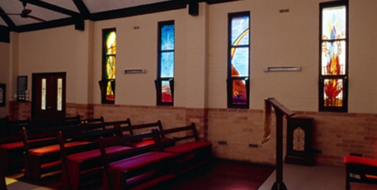 inside of chapel with four stained glass windows