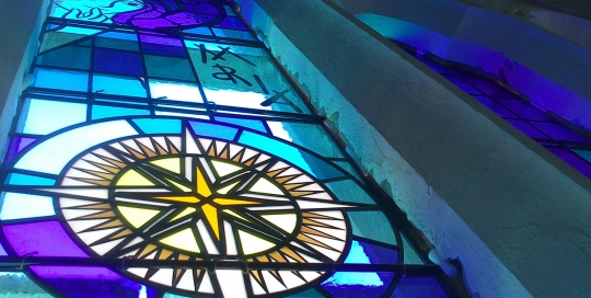 blue stained glass window from below in blue with yellow star