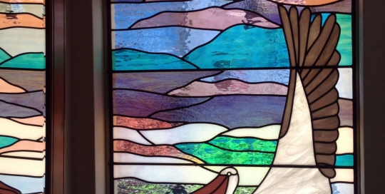 stained glass window of pelican and abstract background