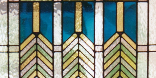 stained glass door panel of clear textured glass and green and yellow geometric patterns