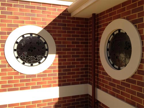 3 two round windows in brick wall