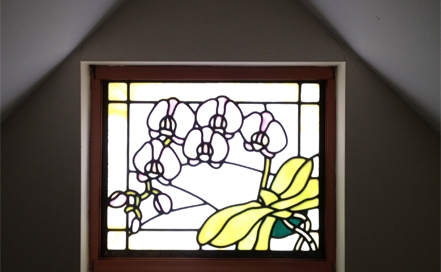orchid stained glass window in wall with pitched ceiling