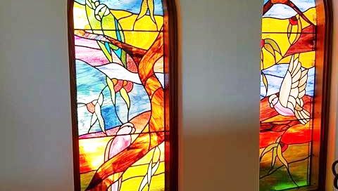 two arched stained glass windows in bright colours with Australian bird designs