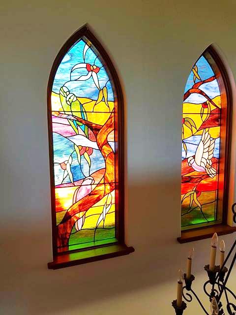 two arched stained glass windows in bright colours with Australian bird designs