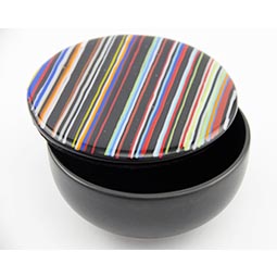 fused glass container with black base and multi coloured striped lid