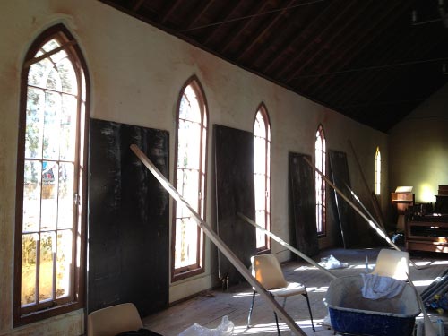 five arched windows of clear glass panels in large church construction site