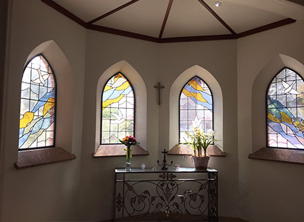 four abstract and dove stained glass arch windows in mausoleum chapel