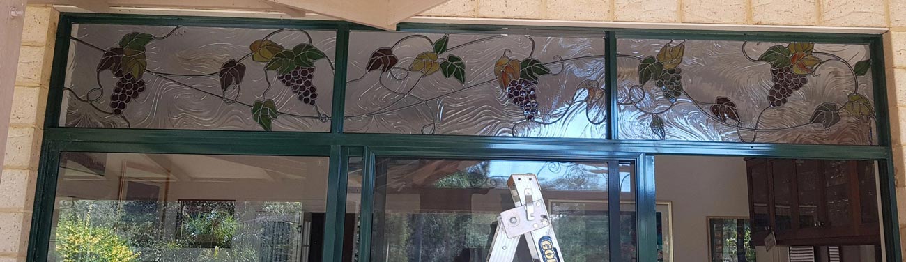 three stained glass grape motif panels above doors leading