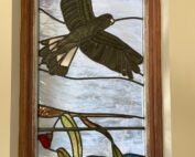 stained glass window depicting flying black cockatoo in Australian landscape
