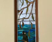 stained glass window depicting black cockatoo in australian landscape