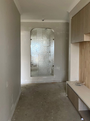 feature slumped glass room divider shown in unfinished hallway