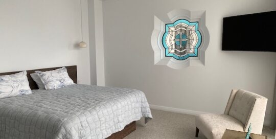 blue coastal geometric stained glass window in bedroom