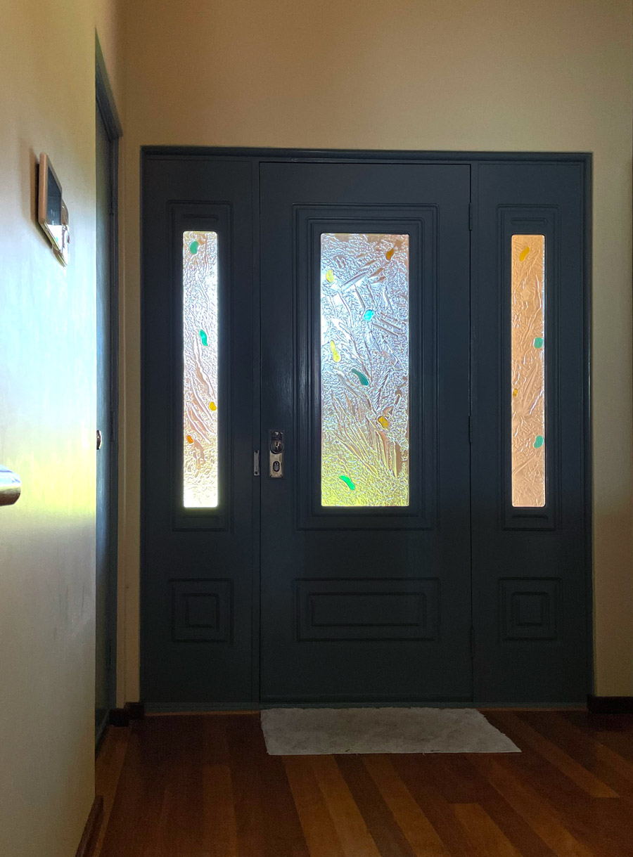 set of 3 kiln formed glass door and door surround panels with laminated coloured pieces shown from inside house