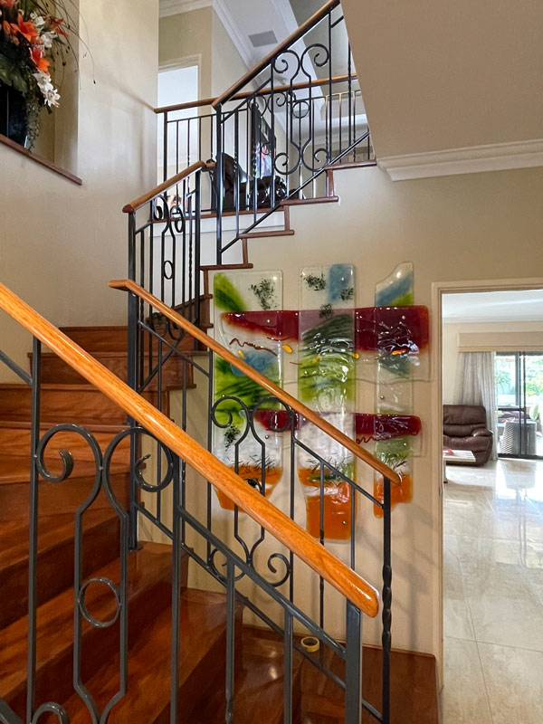 vibrant coloured glass wall art next to stairs