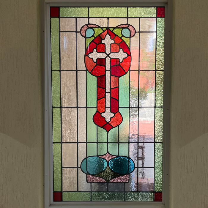 stained glass window with cross in white red and green