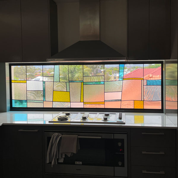 colour and clear texture splashback window with stove below and exhaust above