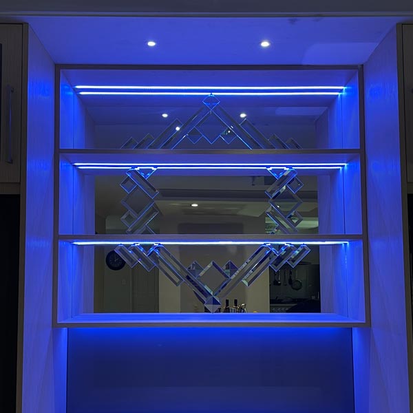 bevelled mirror behind bar shelves lit with blue light