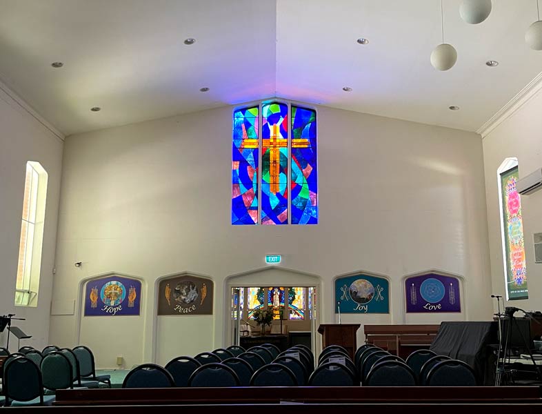colourful leadlight window with cross in church