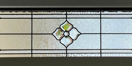 stained glass panel of clear textured glass and floral bevel