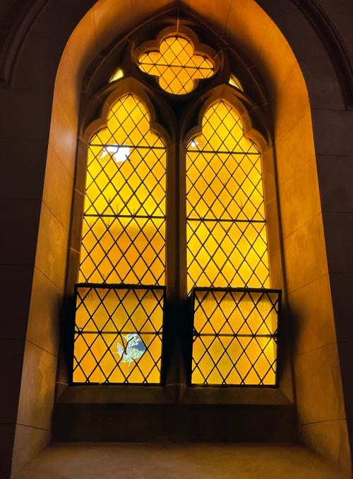 arched window with broken pieces of glass