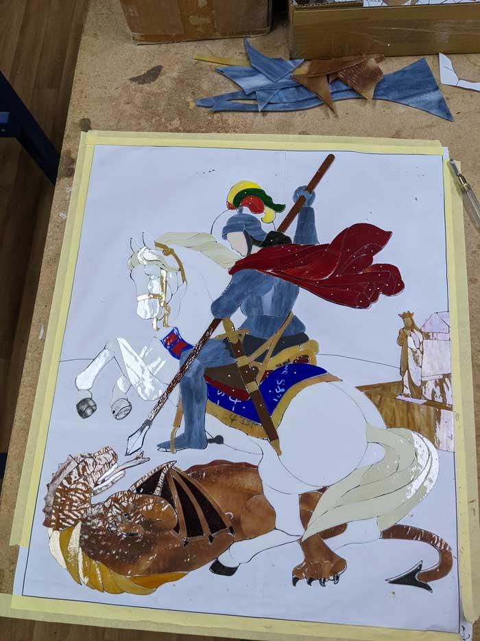 glass mosaic piece of knight on horse being cut