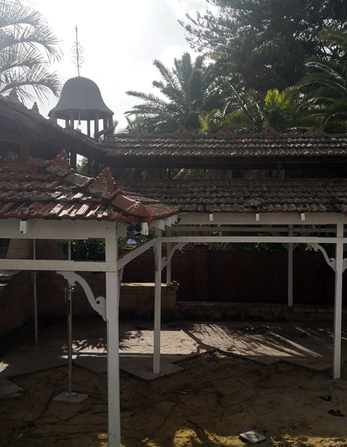 broken down pergola on sand with red brick tile roof