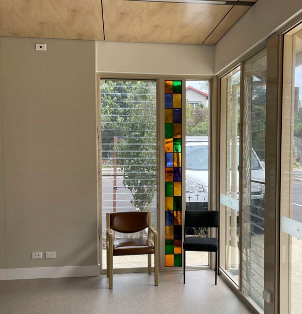 two chairs in front of stained glass lancet window