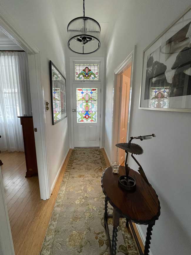 hallway in period home with feature front door with colourful stained glass panels