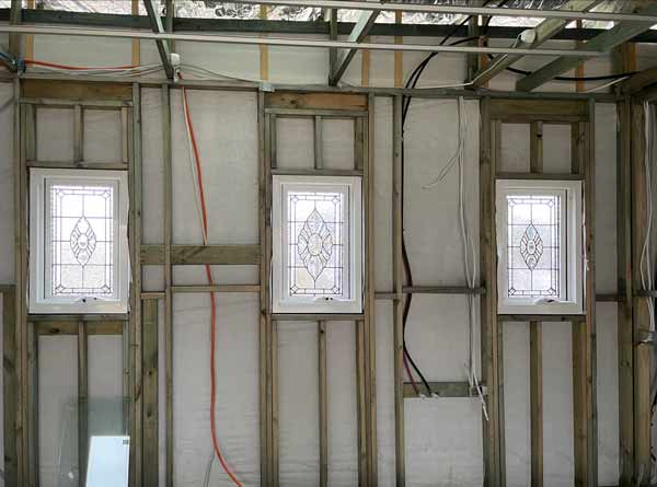 three clear textured leadlight windows in wooden framed house