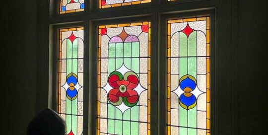 staircase with arch, stained glass window in pastel colours with bright flowers
